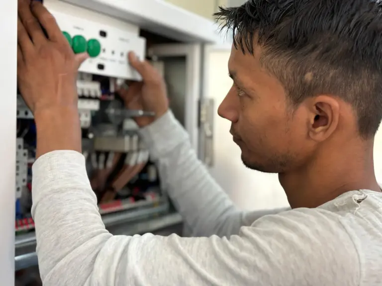 Electrician adjusting circuit breakers in an electrical panel