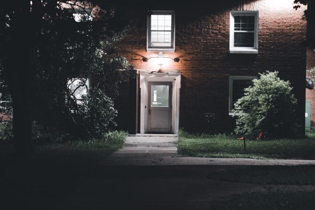 Home entrance and walkway lit with outdoor lighting at night