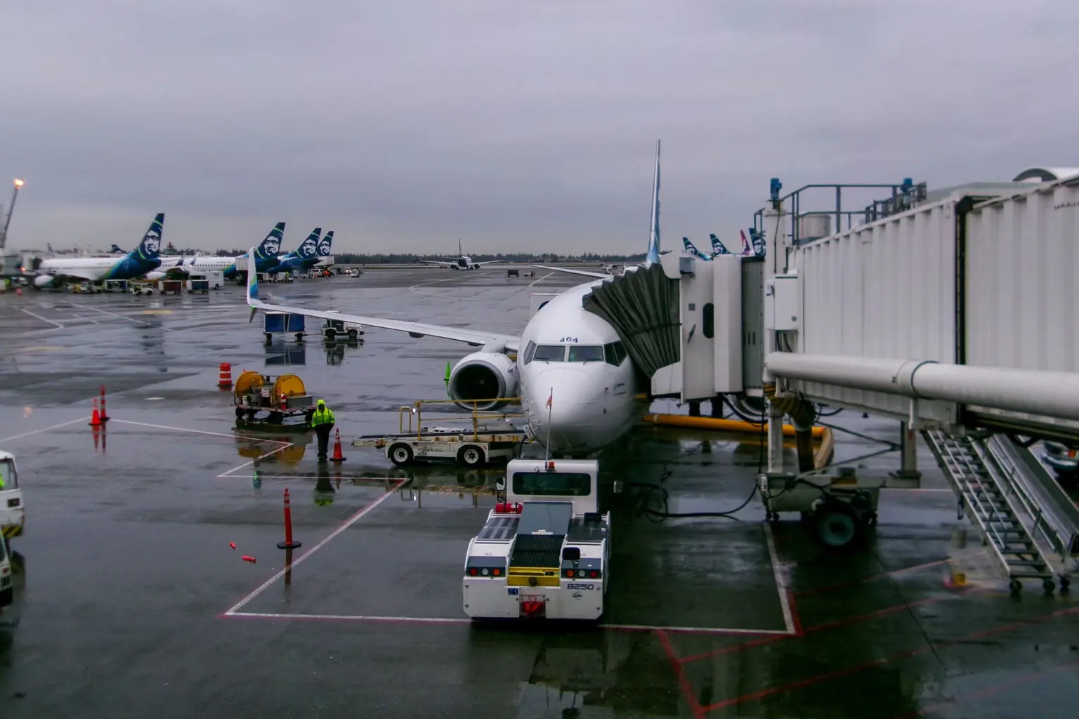 Passenger jet parked at an airport terminal gate on a rainy day